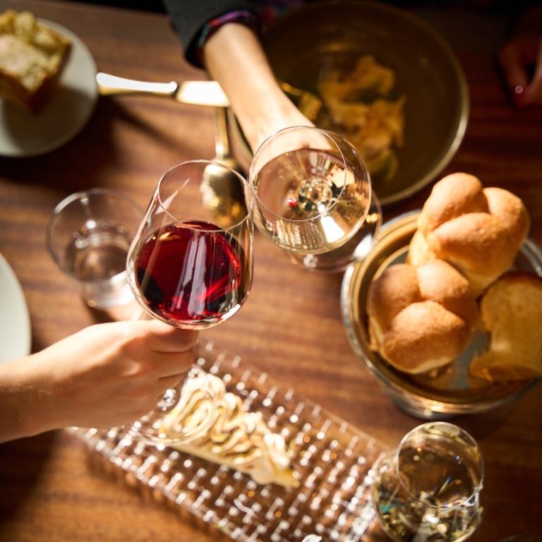 Red and white wine with bread rolls on the table